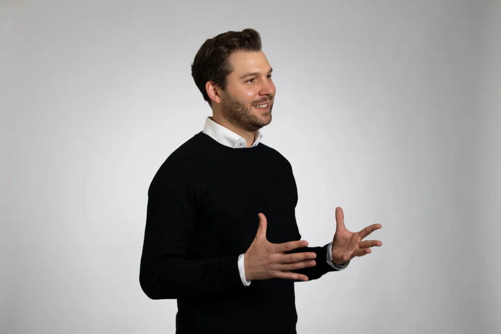 Die Grafik zeigt ein Profilbild des ZSH-Finanzberaters Jens-Frederik Becker mit einladenden Gestik