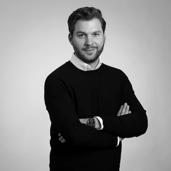 Die Grafik zeigt ein seriöses Profilbild des Finanzberaters Jens-Frederik Becker mit verschränkten Armen, der für ZSH Zahnärzte betreut.